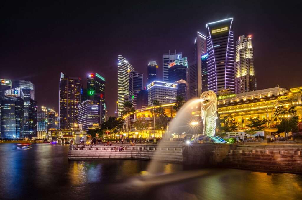 Dazzling view of the Singapore cityscape with Merlion and illuminated skyscrapers at night.